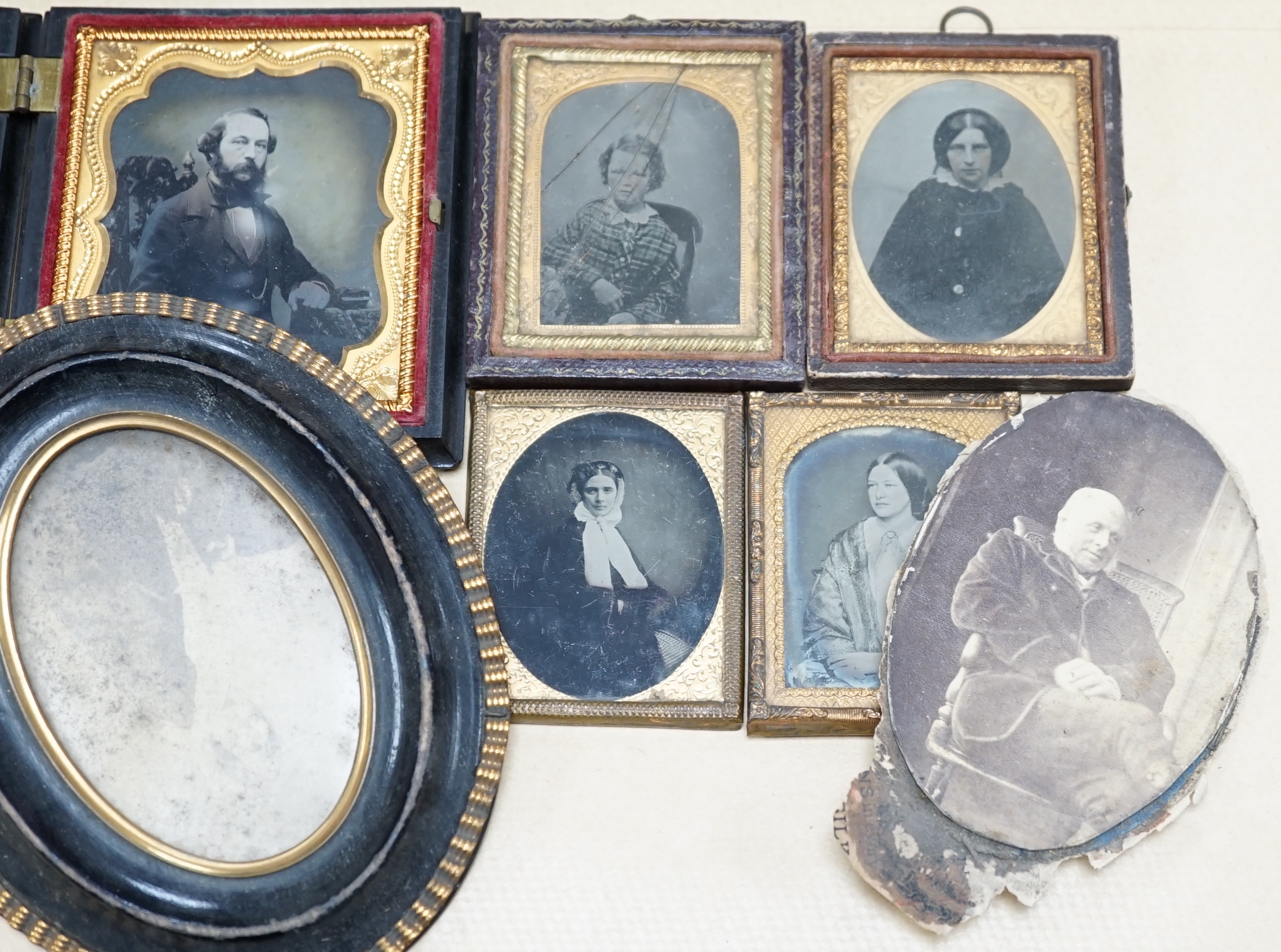 A collection of Victorian ambrotype and black and white photographs including two with original cases, largest 14cm high overall. Condition - poor to fair